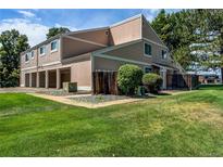 A charming townhouse with a well-manicured lawn, wooden fence, and access to the garage at 8798 Chase Dr # 2, Arvada, CO 80003