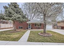 Charming brick home with a well-manicured front yard and beautiful, mature trees at 6970 Upham St, Arvada, CO 80003