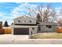Charming two-story home featuring a well-maintained yard, attached garage, and neutral-colored exterior paint at 6985 Braun Ct, Arvada, CO 80004