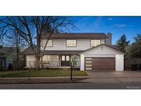 Charming two-story home featuring a modern garage door, covered porch, and fresh landscaping at 4102 W Union Ave, Denver, CO 80236