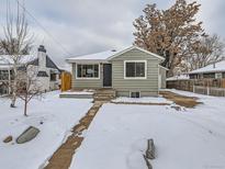 Charming ranch home with snow covered yard and walkway at 4844 Vallejo St, Denver, CO 80221