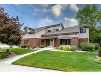 Charming home featuring manicured lawn and mature trees under a bright sky at 8160 W Phillips W Ave, Littleton, CO 80128