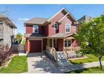 Charming two-story home with a covered front porch and a well-manicured lawn at 10778 Dayton Way, Commerce City, CO 80640