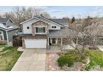 Charming two-story home featuring a stone facade, covered porch, and well-maintained front yard at 5986 Dunraven Ct, Golden, CO 80403