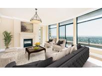 Bright living room with a fireplace, large windows, and neutral decor offers a luxurious feel and stunning city views at 8100 E Union Ave # 2201, Denver, CO 80237