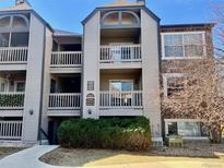 Multi-level condo building with balconies and partial stone facade, surrounded by mature landscaping at 9262 E Arbor Cir # H, Englewood, CO 80111