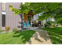 Charming front entrance with brick and wood accents, complemented by cozy seating and a well-manicured lawn at 2420 S Gilpin St, Denver, CO 80210