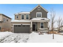 Two-story house with gray siding, a large garage, and snowy front yard at 971 Horsetail Loop, Elizabeth, CO 80107