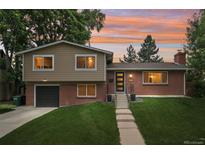 Charming brick home with a well-manicured lawn and colorful sunset backdrop at 6320 E Asbury Ave, Denver, CO 80224