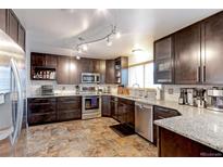 Updated kitchen featuring stainless steel appliances, granite countertops, and ample cabinet space at 10679 Union Way, Broomfield, CO 80021