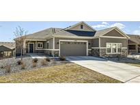 Charming single-story home with a gray exterior, complemented by a stone-accented facade and a spacious two-car garage at 12708 Tamarac St, Thornton, CO 80602