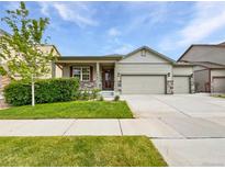 Charming single-story home featuring a three-car garage, covered porch, and well-maintained landscaping at 12742 E 104Th Dr, Commerce City, CO 80022
