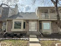 Charming townhome featuring a brick facade, bay windows, and a welcoming front entrance with decorative details at 7624 S Cove Cir, Centennial, CO 80122