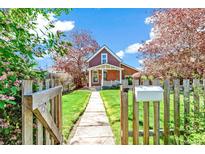 Charming brick home with a well-maintained front yard and a wooden fence with an inviting walkway leading to the front porch at 3513 Quitman St, Denver, CO 80212