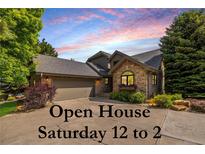 Charming home exterior featuring stone accents, a well-maintained lawn, and a two-car garage, with open house signage at 9 Roder Gate Ln, Castle Pines, CO 80108