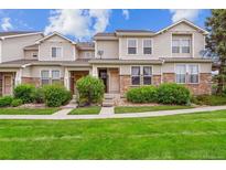Charming townhome with manicured lawn, stone accents, and a welcoming entrance at 178 Blue Bonnet Dr, Brighton, CO 80601