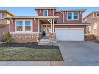 Charming two-story home features a stone facade and a well-manicured lawn, enhancing its curb appeal at 10778 Mountshire Cir, Highlands Ranch, CO 80126