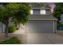 Charming two-story home with gray siding, attached garage, and landscaped front yard at 12717 E Cornell Ave, Aurora, CO 80014