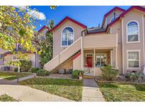 Inviting condo with a quaint red door and stairs leading to an upper-level entrance at 8371 S Upham Way # 208, Littleton, CO 80128