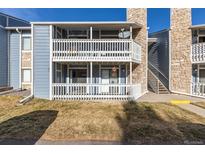 Two-story condo with balconies and stone accents, showcasing a charming residential facade under a clear blue sky at 8335 Fairmount Dr # 4-102, Denver, CO 80247