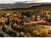 Beautiful exterior view of a home surrounded by lush green trees and mountain views at 7332 Woodglen Pl, Castle Pines, CO 80108