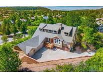 Well-maintained two-story home featuring mature landscaping and a concrete driveway at 7332 Woodglen Pl, Castle Pines, CO 80108