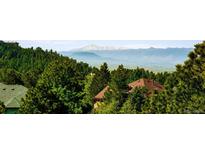 Scenic view of mountains and lush trees from this property provides peaceful and picturesque landscapes at 7332 Woodglen Pl, Castle Pines, CO 80108