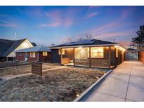 Charming home with solar panels, brick facade, front porch with decorative wood and long driveway at 1742 S Alcott St, Denver, CO 80219