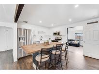Bright kitchen features white cabinets, stainless appliances and a large center island with barstool seating at 1742 S Alcott St, Denver, CO 80219