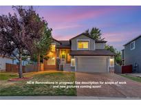 Charming two-story home with a manicured lawn, attached garage, and inviting front porch at 17166 Yellow Rose Way, Parker, CO 80134