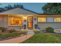 Charming ranch home with landscaped lawn and inviting front porch at 3701 W Greenwood Pl, Denver, CO 80236