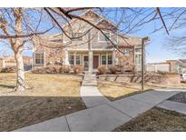 Charming townhome with stone accents, a well-manicured lawn, and a cozy front porch at 12814 Jasmine St # C, Thornton, CO 80602