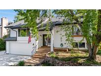Charming home featuring manicured landscaping, an attached garage, and an inviting entryway with stairs at 6700 W 80Th Cir, Arvada, CO 80003