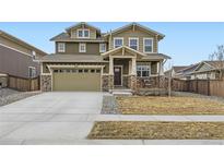 Beautiful two-story home with a stone facade, two-car garage, and well-maintained lawn at 1853 Griffin Dr, Brighton, CO 80601