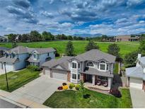 Inviting two-story home with a well-manicured lawn and colorful flowerbeds, set against a scenic backdrop at 1825 Keota Ln, Superior, CO 80027