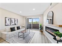 Bright living room with modern fireplace, sliding glass doors, and neutral decor create an inviting atmosphere at 4274 S Salida Way # 3, Aurora, CO 80013