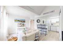 Bright living room featuring a modern sofa, decor, and a view into the updated kitchen at 8701 Huron St # 1-207, Thornton, CO 80260