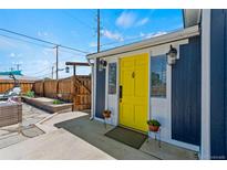 Charming home featuring a bright yellow front door, with stone walkway and landscaped yard at 1390 Emporia St, Aurora, CO 80010