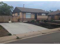 Charming brick home featuring a spacious driveway, well-maintained landscaping, and a cozy, inviting front porch at 7625 Turner Dr, Denver, CO 80221