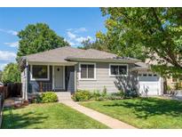 Charming single-story home featuring a well-maintained lawn, garden beds, and a welcoming front porch at 1627 S Saint Paul St, Denver, CO 80210