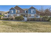 Charming townhome with blue and brown exterior, manicured lawn, and inviting front porch at 13255 Holly St # B, Thornton, CO 80241