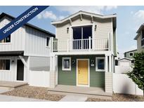 Charming two-story home with a balcony, yellow door, and durable gravel landscaping at 13040 E 103Rd Ave, Commerce City, CO 80022