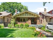 Charming brick bungalow with a well-manicured front yard and inviting curb appeal at 843 Adams St, Denver, CO 80206