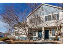 Two-story townhome with blue accents, covered porch, and mature landscaping at 9576 Deerhorn Ct # 50, Parker, CO 80134