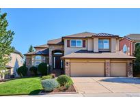 Charming two-story home featuring a three-car garage, beautiful stone accents, and a well-manicured lawn at 1328 Double Eagle Ct, Castle Rock, CO 80104