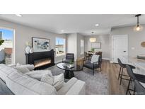Comfortable living room featuring a fireplace, modern decor, and open layout to the kitchen and dining areas at 2140 S Ash St # 101, Denver, CO 80222