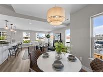 Open concept living space with kitchen island, dining area, and comfortable seating, filled with natural light at 2140 S Ash St # 101, Denver, CO 80222