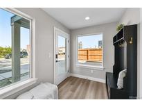 Bright mud room with storage bench, white door, and windows providing lots of natural light at 2140 S Ash St # 101, Denver, CO 80222