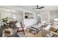 Bright living room features modern furnishings, neutral decor, and an open layout that flows into the kitchen at 1330 Oak Pl, Thornton, CO 80229