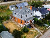 Two-story home boasts a new roof, solar panels, gray siding, and a brick foundation at 1520 Virginia St, Idaho Springs, CO 80452
